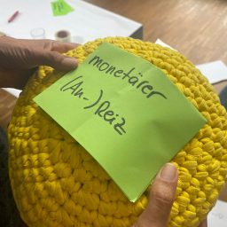 Gelbes Handgefertigtes Objekt mit einem Haftnotizzettel, darauf steht "Monetärer Anreiz".